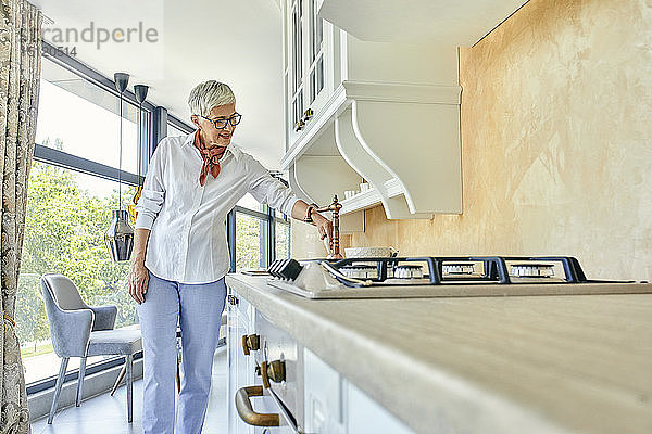 Reife Frau in einem Küchenmöbel-Ausstellungsraum