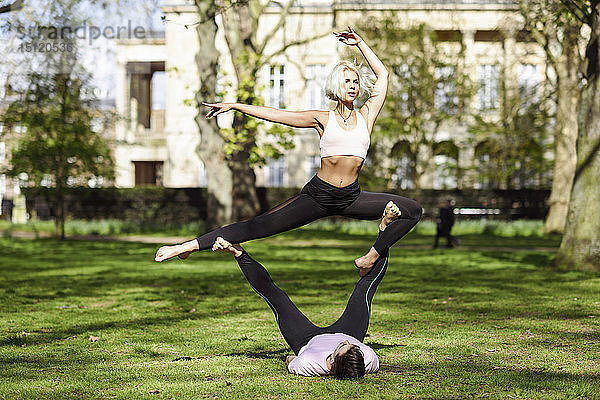 Junges Paar macht Yoga-Akrobatik in einem städtischen Park