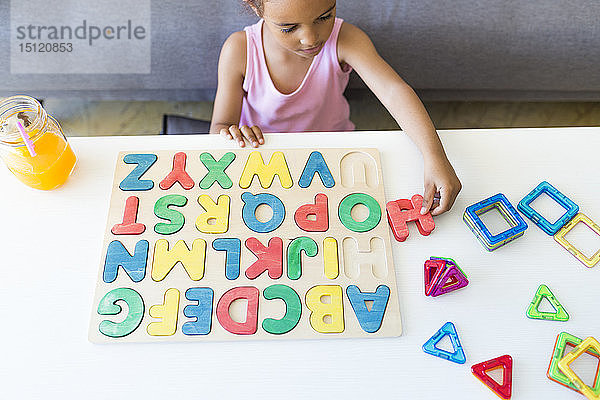 Mädchen spielt zu Hause mit Alphabet-Lernspiel