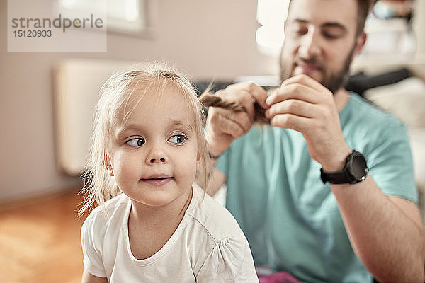 Vater flechtet die Haare seiner Tochter