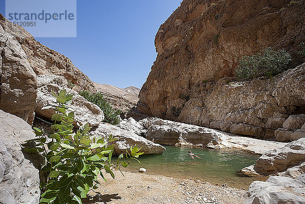Mann schwimmt in einem kleinen See im Wadi Bani Khalid  Oman