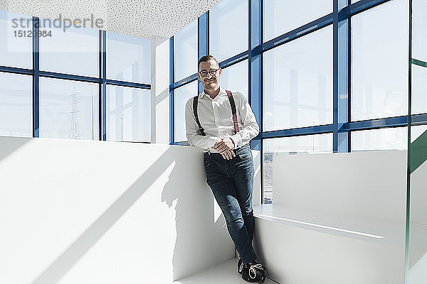 Porträt eines selbstbewussten Geschäftsmannes am Fenster in einem modernen Büro