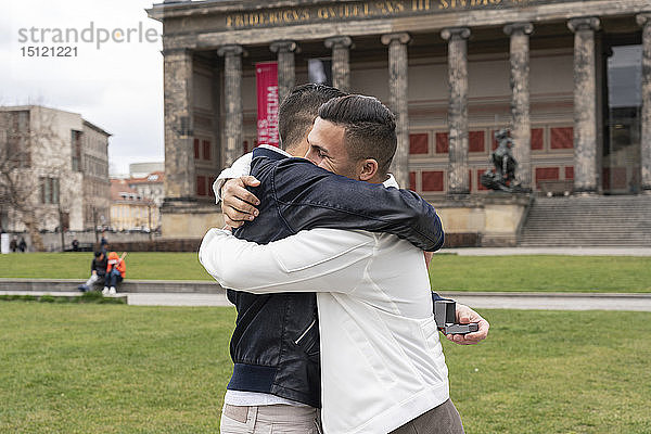 Junger Mann macht seinem Freund einen Heiratsantrag und umarmt sich im Lustgarten  Berlin  Deutschland