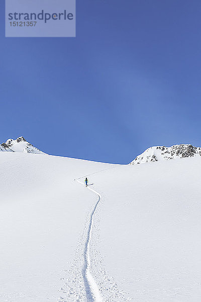 Österreich  Tirol  zwischen Ischgl und Galtür  Hohe Koepfe  Skitourengeher  der im Winter auf den Gipfel steigt