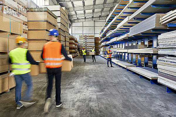 Arbeiter bewegen und tragen Kisten im Fabriklager