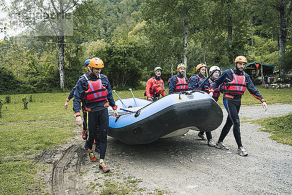 Eine Gruppe von Freunden bereitet sich mit einem Schlauchboot auf eine Rafting-Tour vor