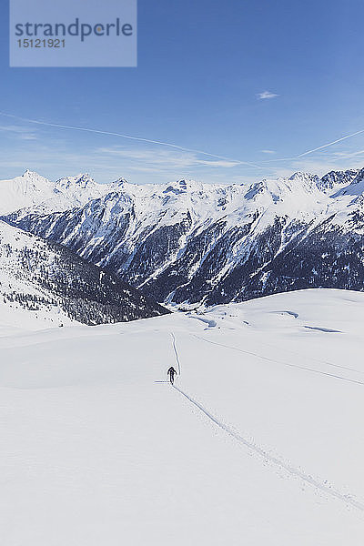 Österreich  Tirol  zwischen Ischgl und Galtür  Hohen Koepfen  Skitourengeher  der im Winter auf den Gipfel steigt