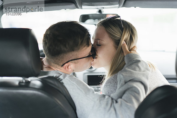 Junges Paar küsst sich in einem Auto
