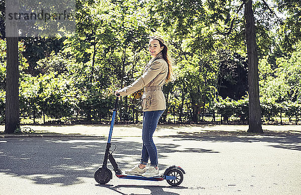 Porträt einer lächelnden Frau mit E-Scooter