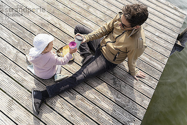 Deutschland  Bayern  Herrsching  Vater und Tochter entspannen sich auf dem Steg bei einem Imbiss