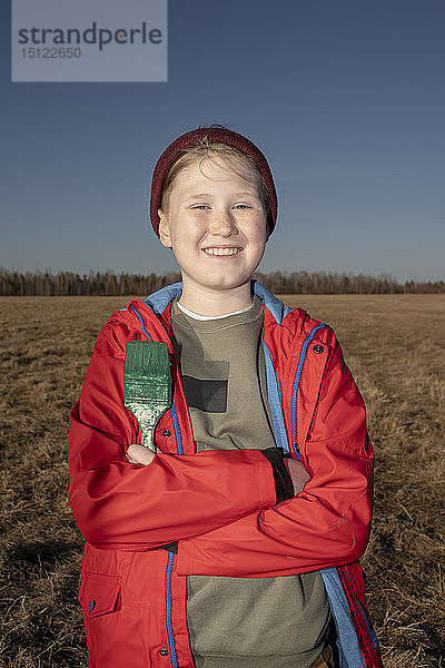 Porträt eines lächelnden Jungen mit Pinsel in der Steppenlandschaft