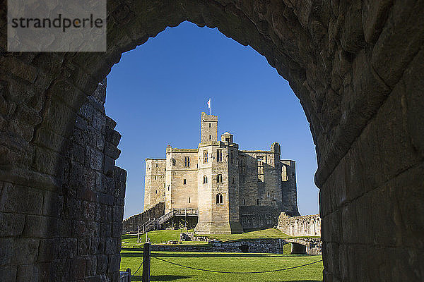 Blick durch den Bogen über die Rasenflächen auf den Großen Turm der Burg Warkworth  Warkworth  Northumberland  England  Vereinigtes Königreich  Europa