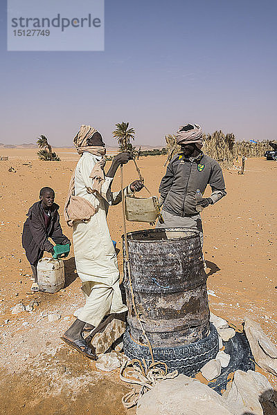 Einheimische Jungen schöpfen Wasser aus ihrem Brunnen in der Wüste zwischen Ounianga Kebir und Faya  Nordtschad  Afrika