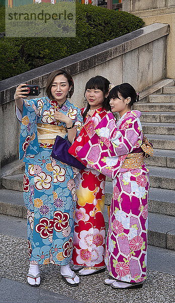 Junge Japanerinnen in bunten Kimonos machen Selfies in Kyoto  Japan  Asien
