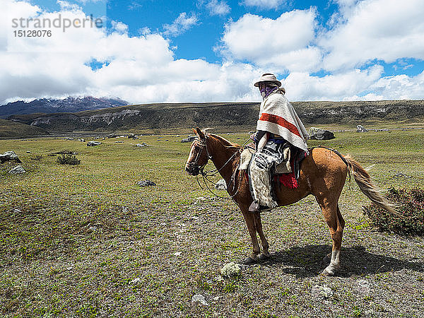 Indigener Mann auf einem Pferd in hoher Paramolandschaft  Cotopaxi-Nationalpark  Anden  Ecuador  Südamerika