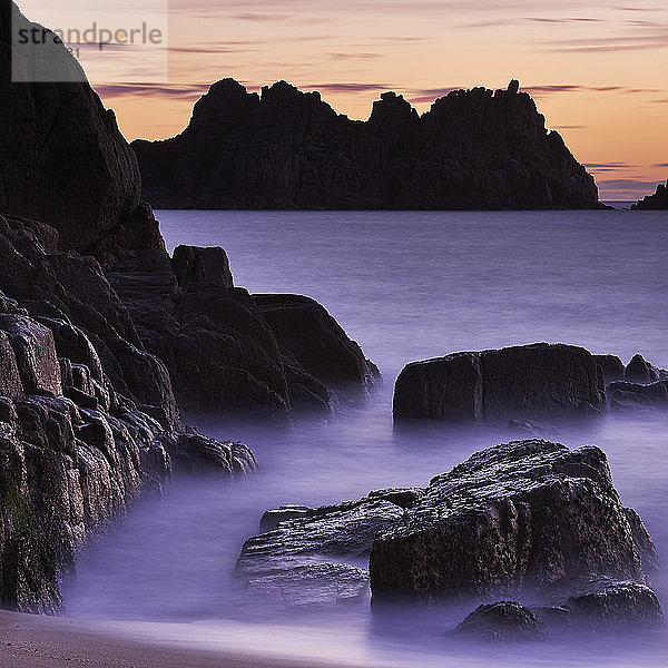Frühmorgens am Strand mit Blick auf den Logan Rock bei Porthcurno  Cornwall  England  Vereinigtes Königreich  Europa