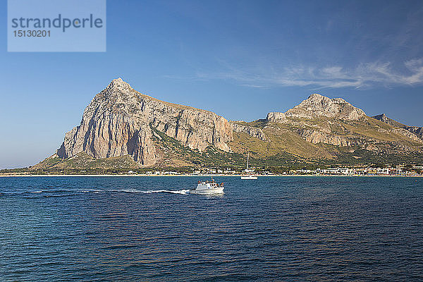 Blick über die Bucht auf den Monte Monaco und den Pizzo di Sella  kleines Boot bei der Rückkehr in den Hafen  San Vito Lo Capo  Trapani  Sizilien  Italien  Mittelmeer  Europa