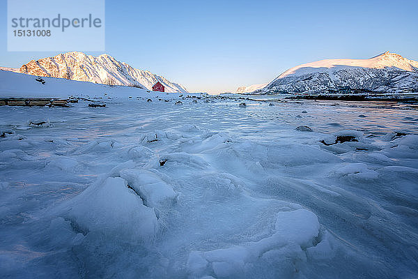 Rorbuer (Fischerhütte) auf einem zugefrorenen See  Lofoten  Nordland  Arktis  Norwegen  Europa