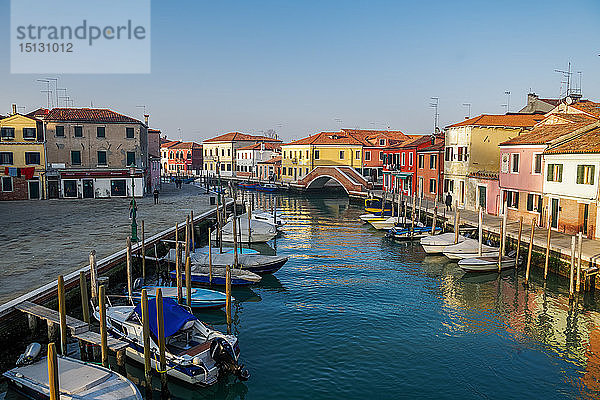Blick auf die steinerne Brücke Ponte San Martino über den Kanal mit bunten Gebäuden und vertäuten Booten auf hölzernen Kaipfeilern  Venedig  UNESCO-Weltkulturerbe  Venetien  Italien  Europa