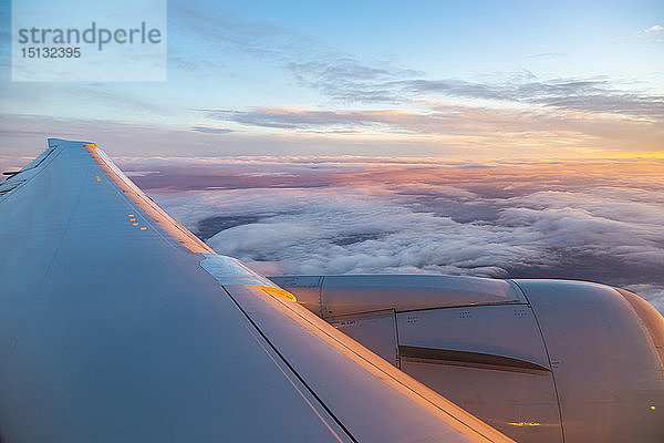 Allgemeiner Blick aus dem Flugzeugfenster auf Flugzeugflügel und Sonnenaufgang über England  Vereinigtes Königreich  Europa