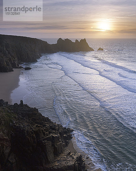 Sonnenaufgang über dem schönen und abgelegenen Strand von Pedn Vounder mit Blick auf Logan Rock  nahe Porthcurno  Cornwall  England  Vereinigtes Königreich  Europa