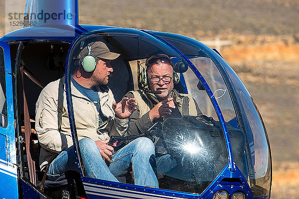 Hubschrauber und Piloten am Boden in ländlicher Umgebung  Kapstadt  Westkap  Südafrika