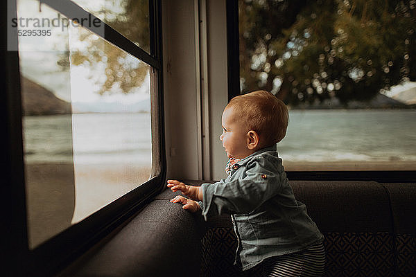 Baby schaut aus dem Fenster eines Wohnmobils  Wanaka  Taranaki  Neuseeland