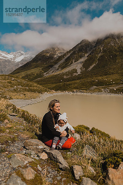 Mutter mit Baby genießt malerische Aussicht am See  Wanaka  Taranaki  Neuseeland