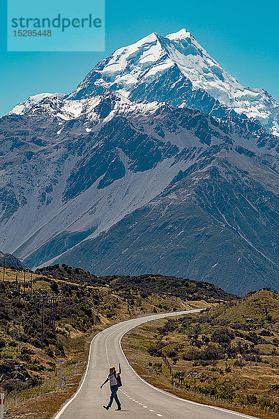 Wanderer überquert Straße  die in die Berge führt  Wanaka  Taranaki  Neuseeland