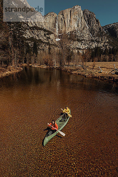 Junges Kanu-Paar beim Kanufahren auf dem Fluss  Hochwinkelansicht  Yosemite Village  Kalifornien  USA