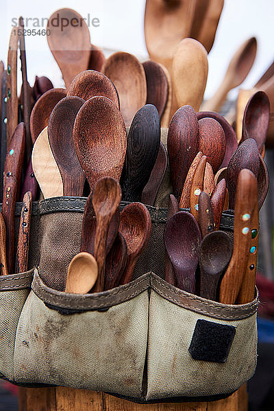 Werkzeuggürtel gefüllt mit Holzlöffeln und Messern