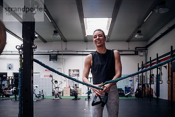 Junge Frau  die im Fitnessstudio die Arme streckt