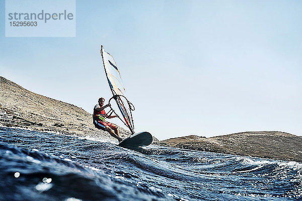 Zurückgelehnter junger Mann beim Windsurfen auf Meereswellen  Blick auf die Oberfläche  Limnos  Khios  Griechenland