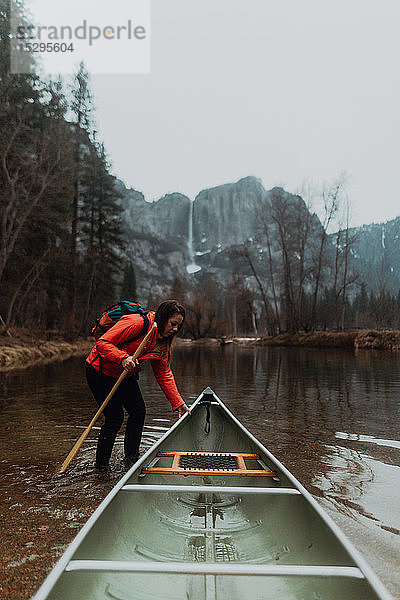 Junge Kanufahrerin zieht Kanu im Fluss  Yosemite Village  Kalifornien  USA