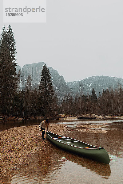Junge Kanufahrerin beim Ziehen eines Kanus vom Fluss  Yosemite Village  Kalifornien  USA