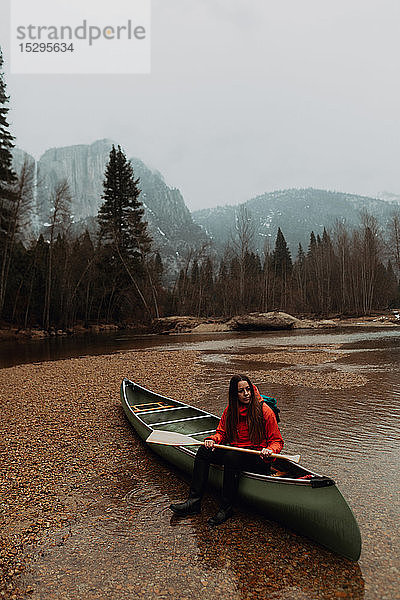 Junge Kanufahrerin sitzt im Fluss auf einem Kanu  Yosemite Village  Kalifornien  USA