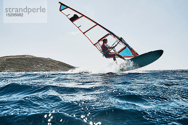 Junger Mann in der Luft beim Windsurfen auf Meereswellen  Limnos  Khios  Griechenland