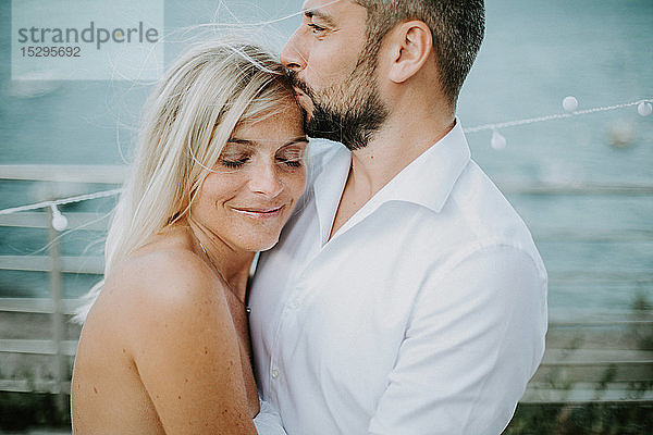 Romantischer mittelgroßer Mann küsst am Seeufer die Stirn seiner Freundin  Stresa  Piemont  Italien