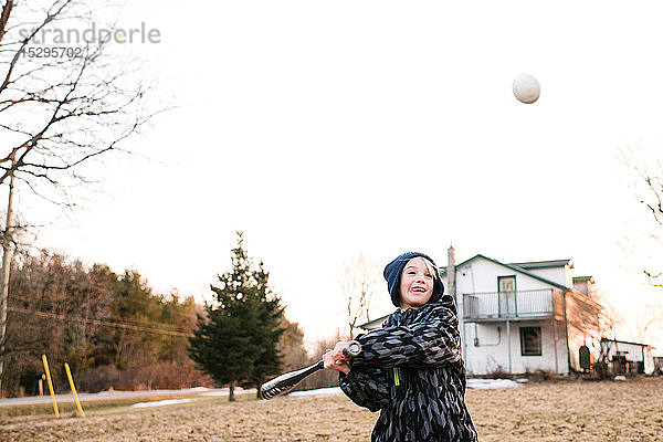 Junge schlägt Baseball auf ländlichem Feld  Aktion