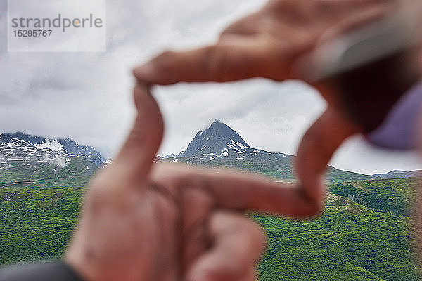 Älterer Mann und Sohn umrahmen Berggipfel mit den Händen  Nahaufnahme  Valdez  Alaska  USA