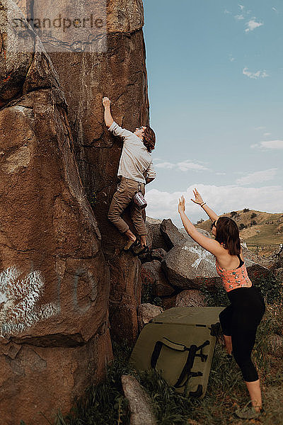 Junger Mann klettert eine Felswand hoch  Freundin schaut zu  Exeter  Kalifornien  USA