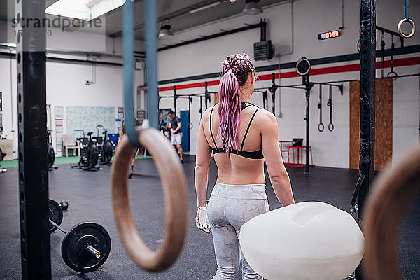 Junge Frau trainiert im Fitnessstudio