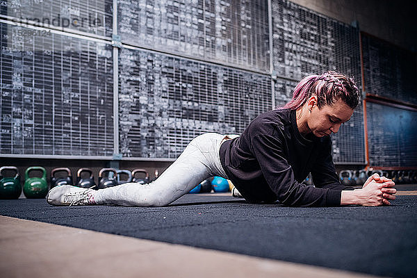 Junge Frau beim Stretching im Fitnessstudio