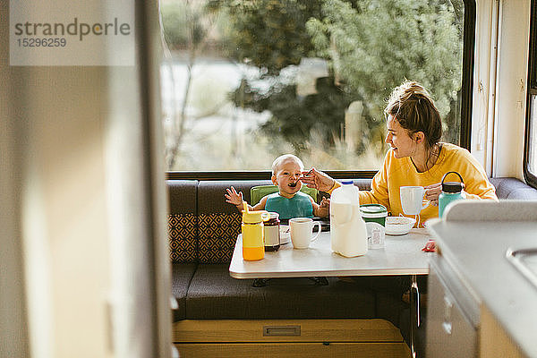 Mutter füttert Baby-Frühstück im Wohnmobil
