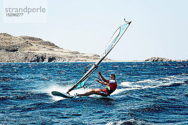 Junger Mann beim Windsurfen auf Meereswellen  Limnos  Khios  Griechenland