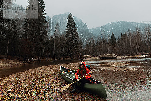 Glückliche junge Kanufahrerin sitzt im Fluss auf einem Kanu  Yosemite Village  Kalifornien  USA