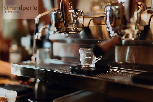 Leere Messkanne auf Kaffeemaschinenständer im Café