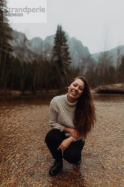 Junge Frau im Fluss kauernd  Porträt  Yosemite Village  Kalifornien  USA