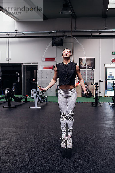 Junge Frau springt im Fitnessstudio