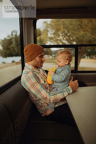 Vater und Baby entspannen sich im Wohnmobil  Wanaka  Taranaki  Neuseeland